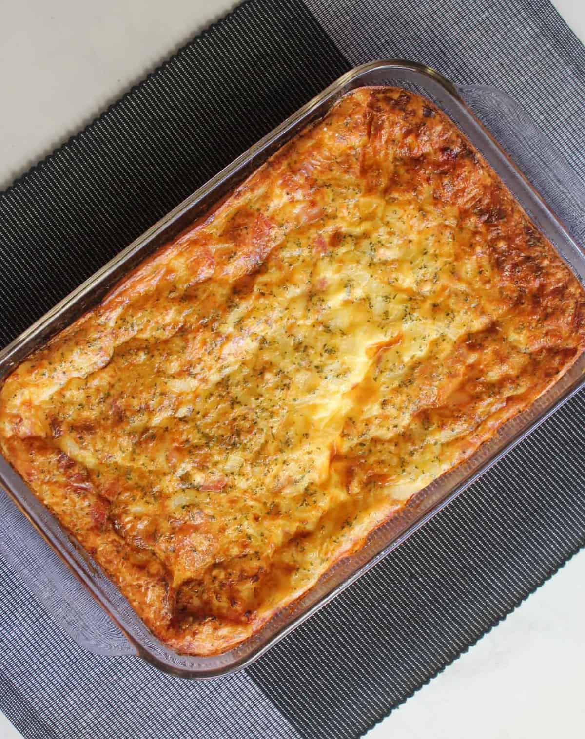 Egg and Bacon Pie in a baking dish on a black and grey background