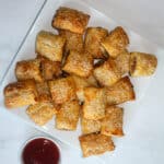 Sausage Rolls on a white plate with sauce