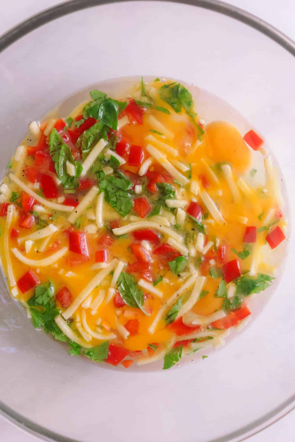 Raw Egg muffin ingredients in a glass bowl.