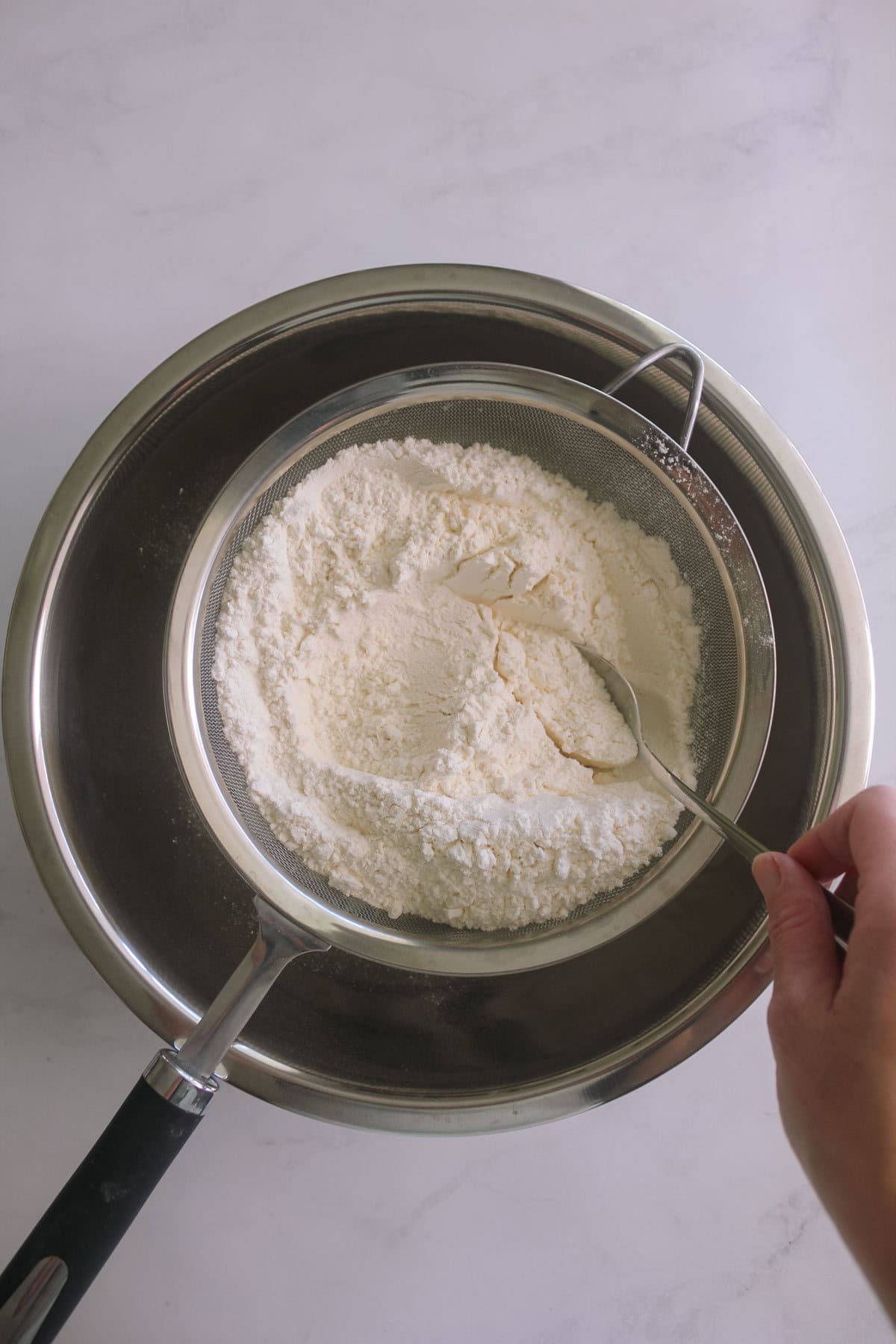 Flour being sifted into a bowl