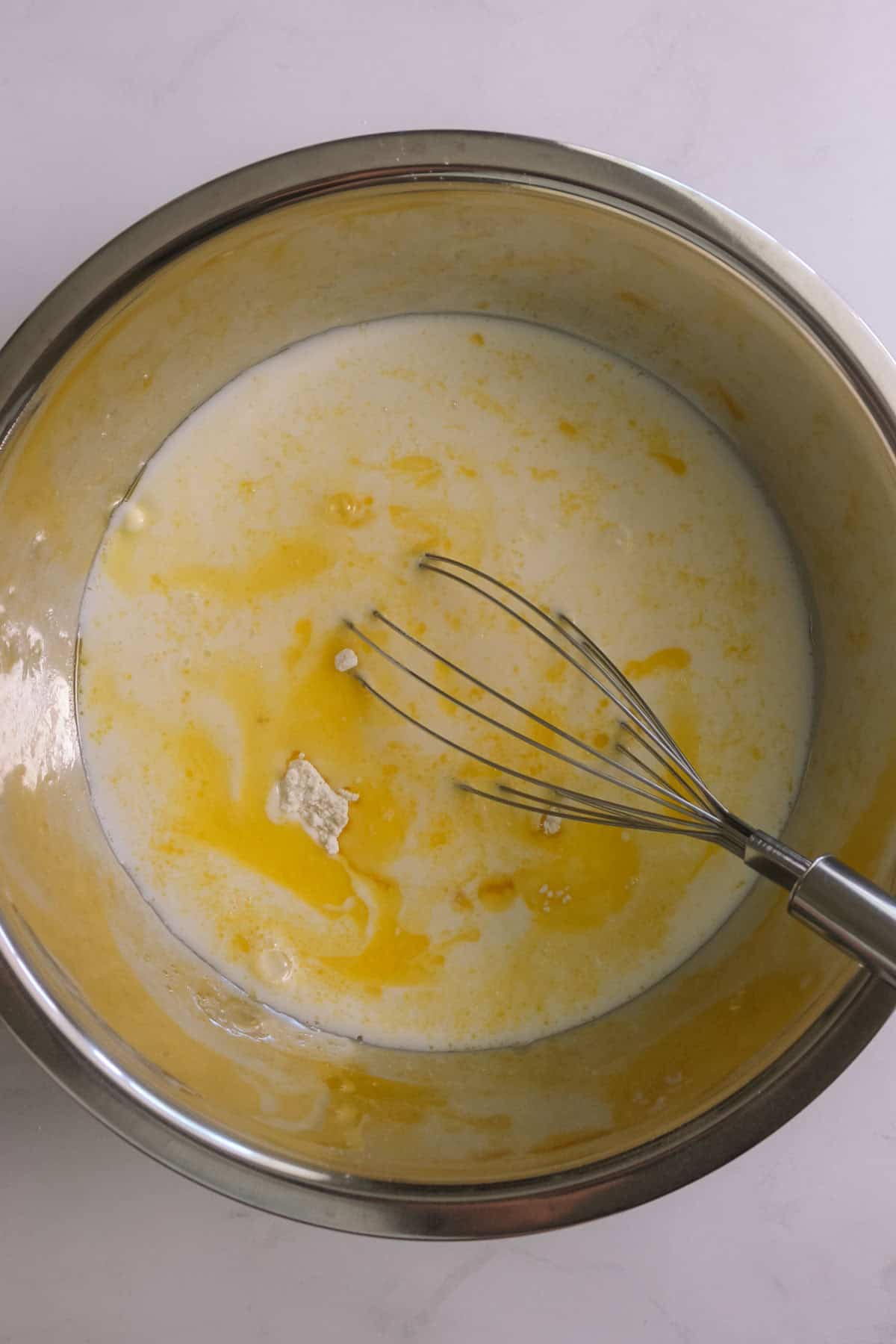 Wet and dry ingredients in a bowl with a whisk