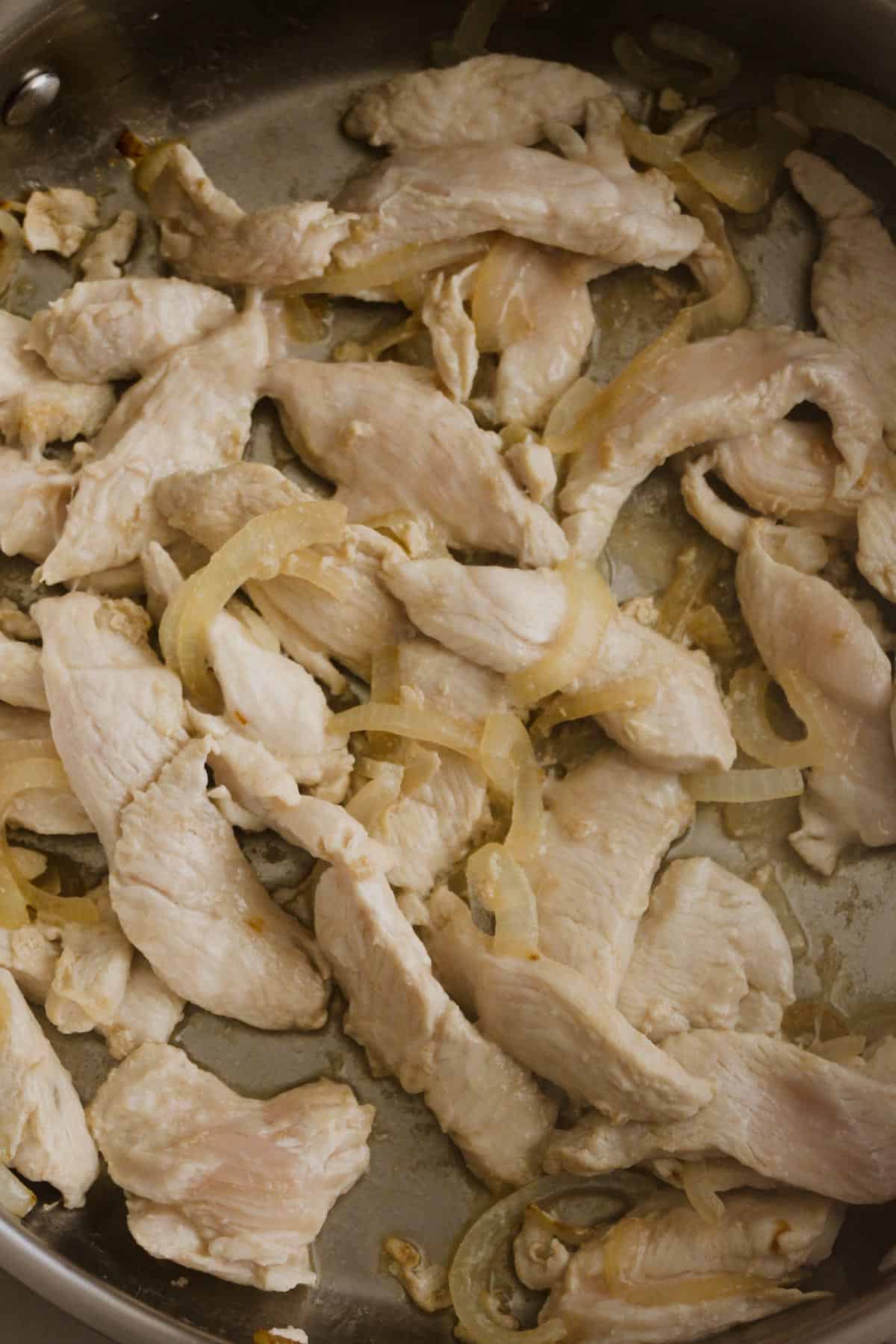 Chicken breast seared in a frypan, partially cooked