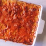 Creamy cheesy potato bake in a white baking dish