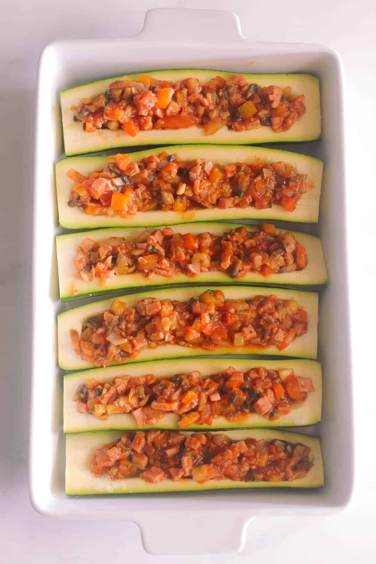Zucchini boats filling cooked and, in a frypan,