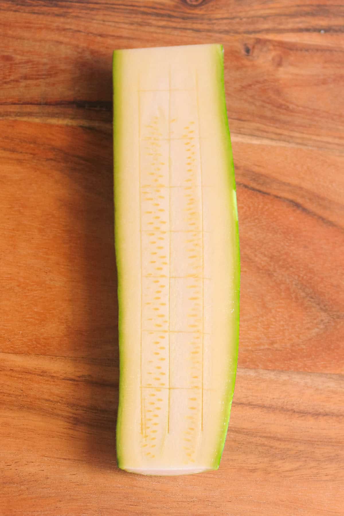 Zucchini sliced in half and scored to help scoop flesh out